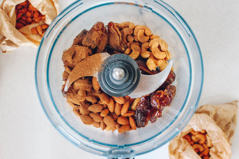 Food processor filled with nuts and dried fruit
